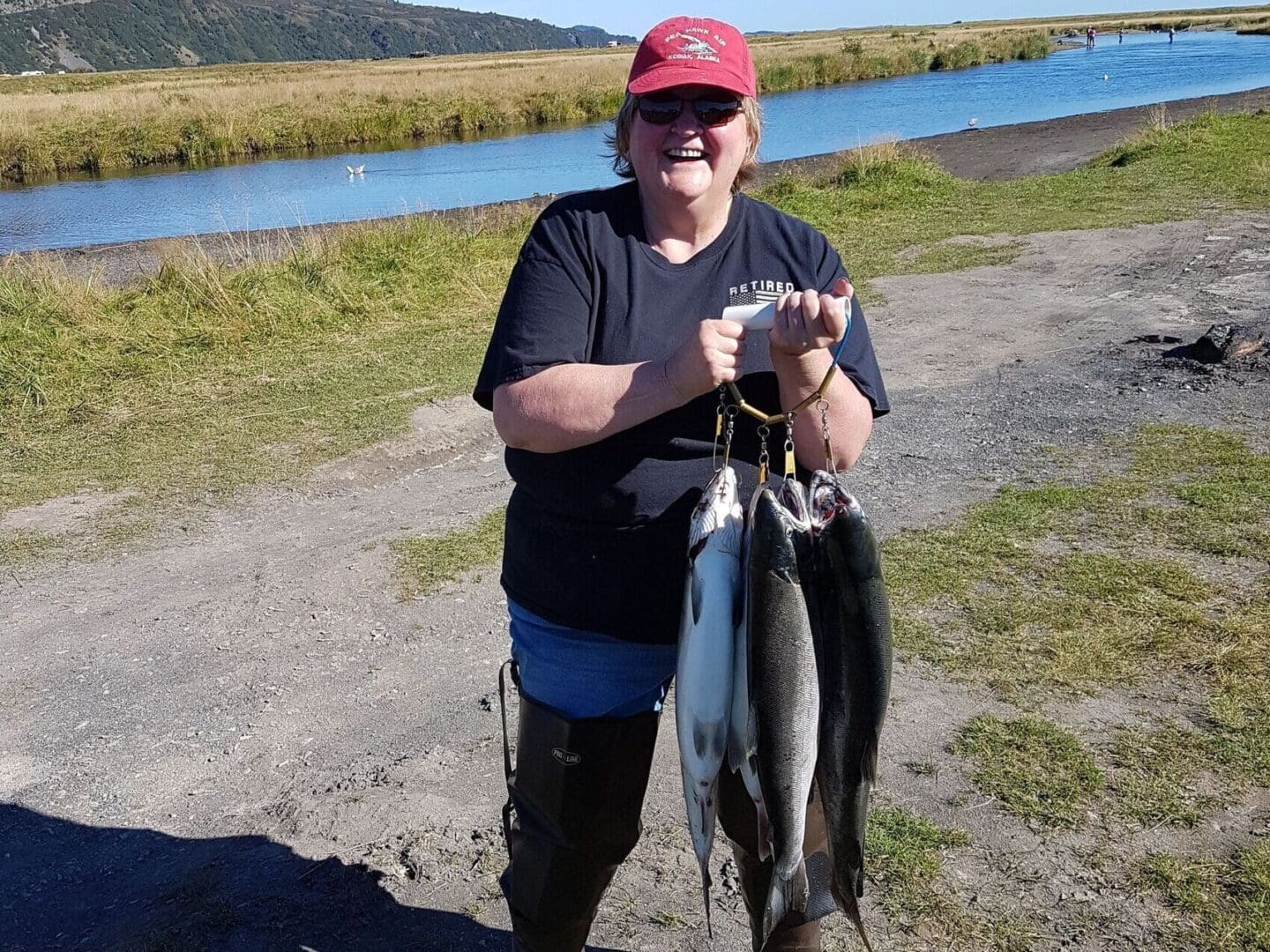 A woman holding two fish in her hands.